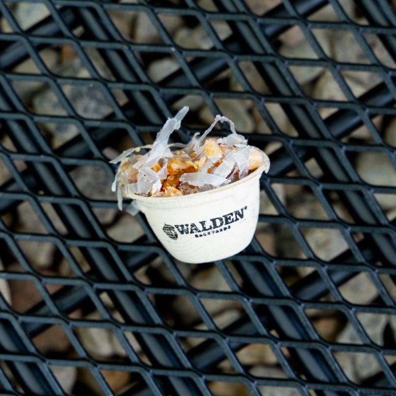 Walden Sure-Fire Starter placed in the center of a fire grate inside a fire pit